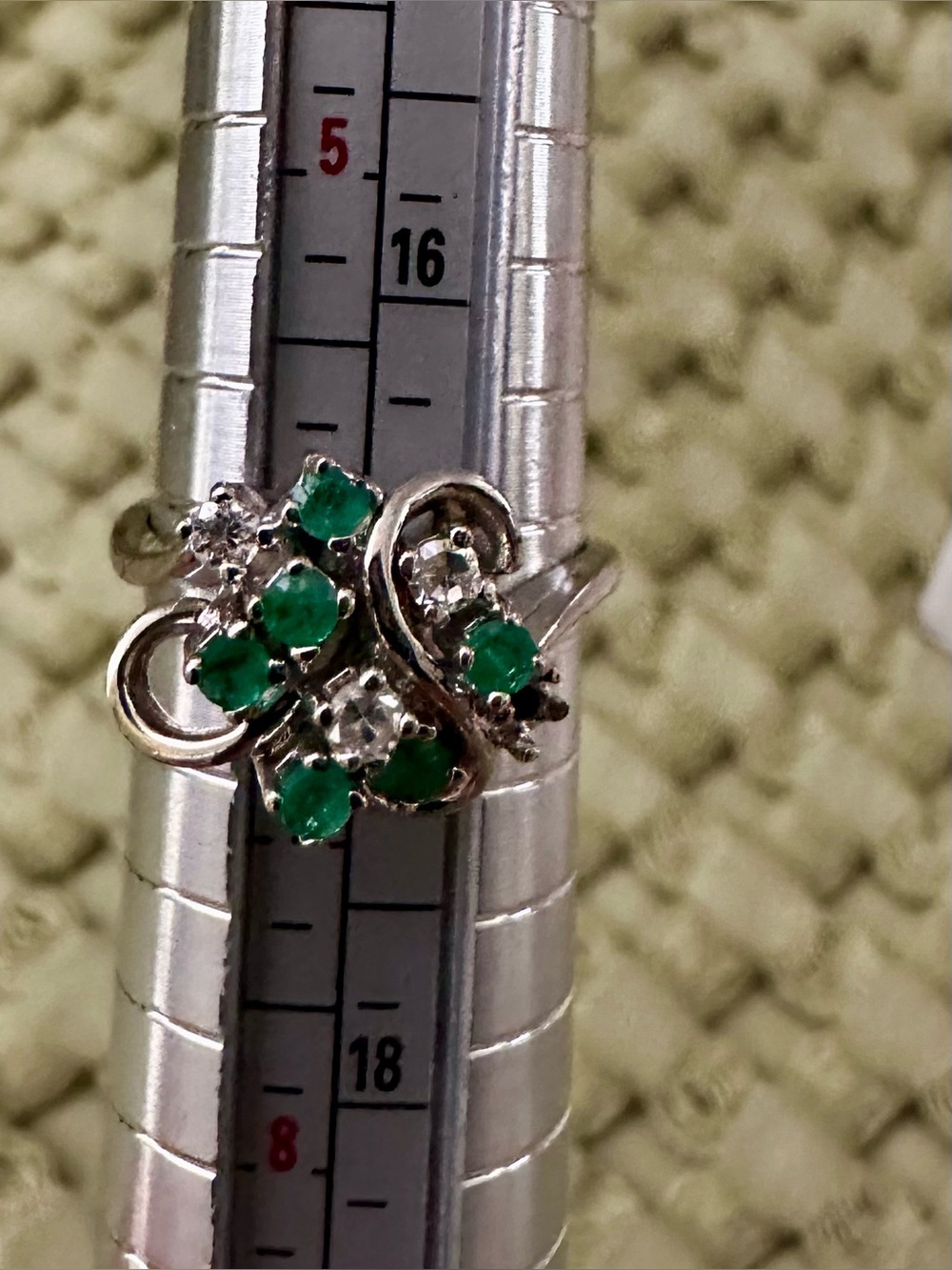 14 k white gold with emeralds and diamonds .  One small stone missing